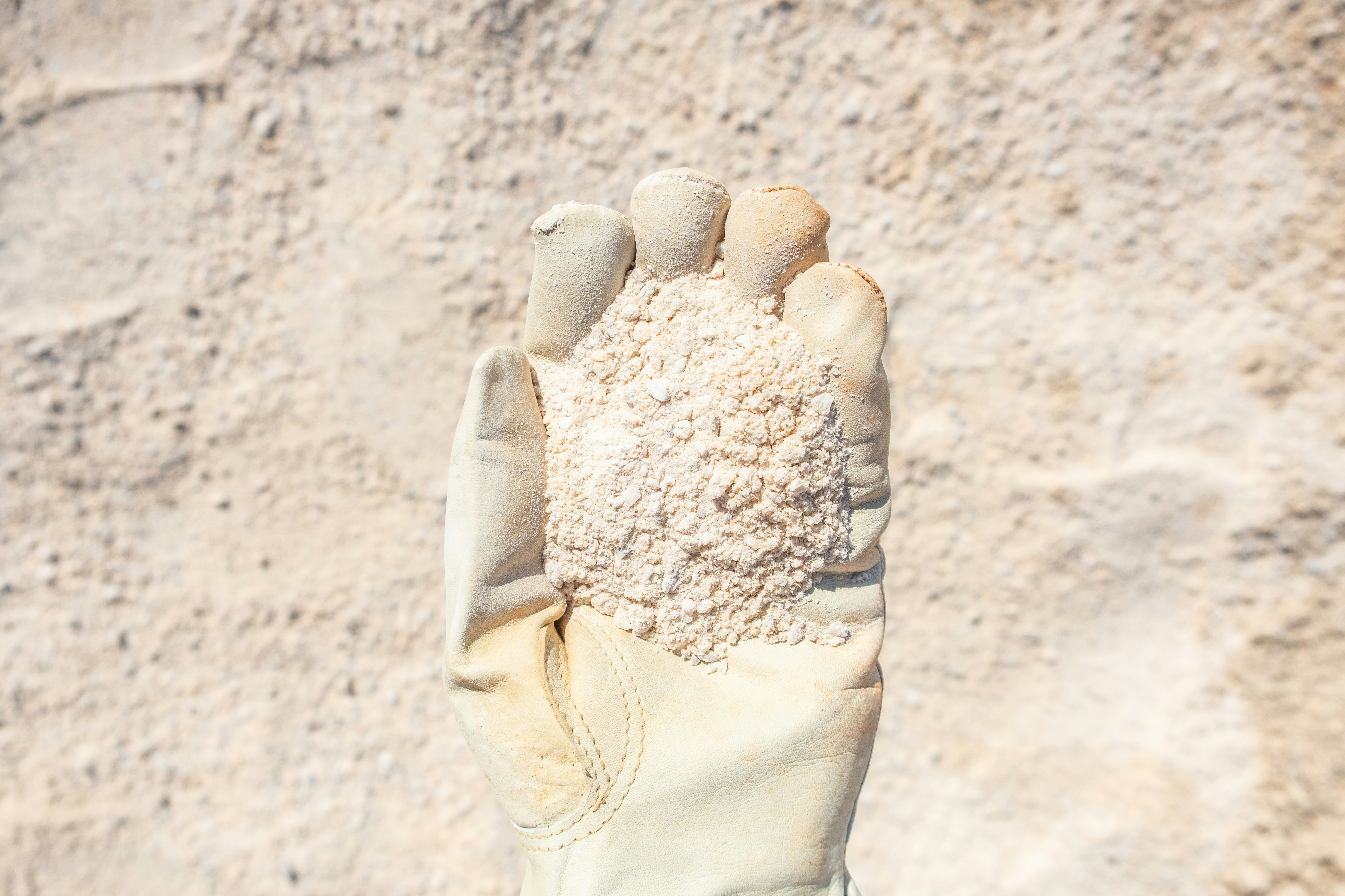 Gloved Hand Holding Dry Soil