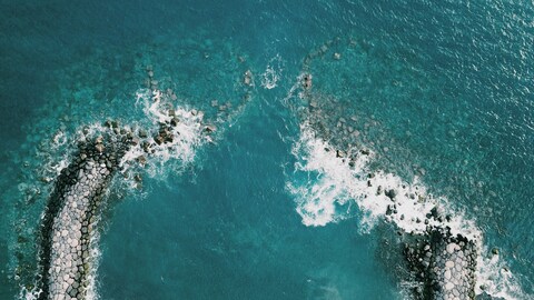 Aerial View of Broken Stone Breakwater in Sea