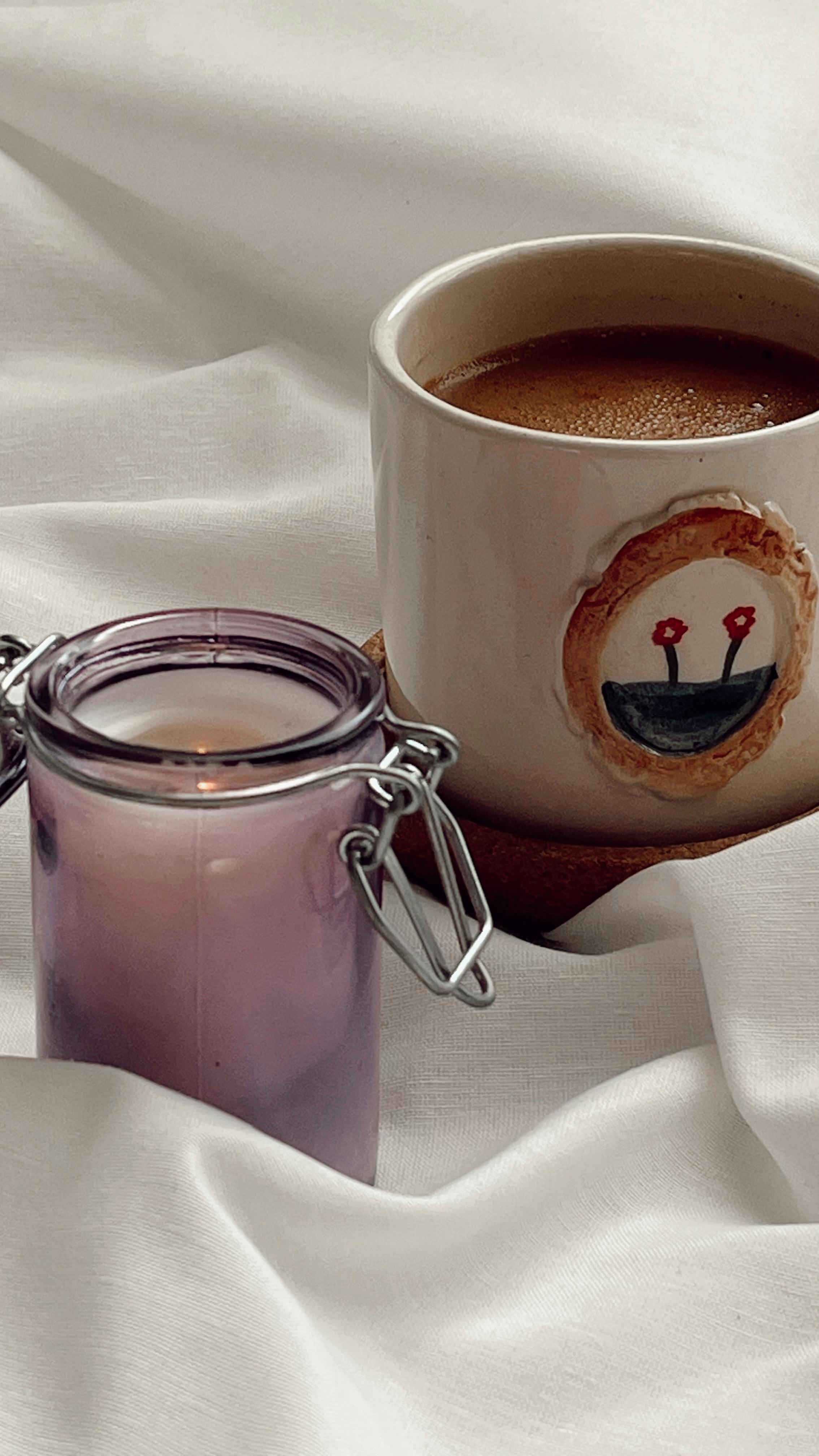 Coffee Mug and Lit Lavender Candle