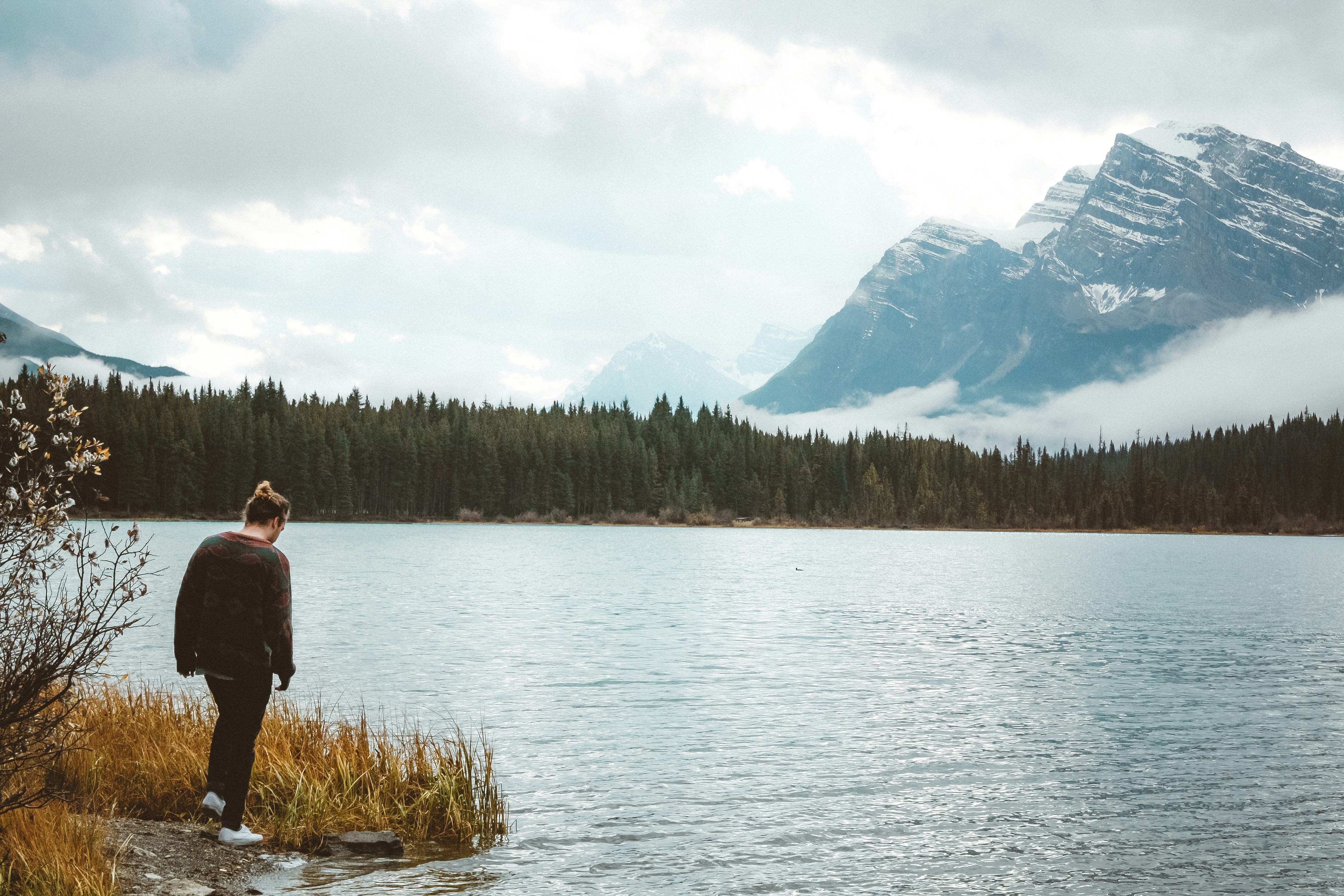 Man Standing by Mountain Lake