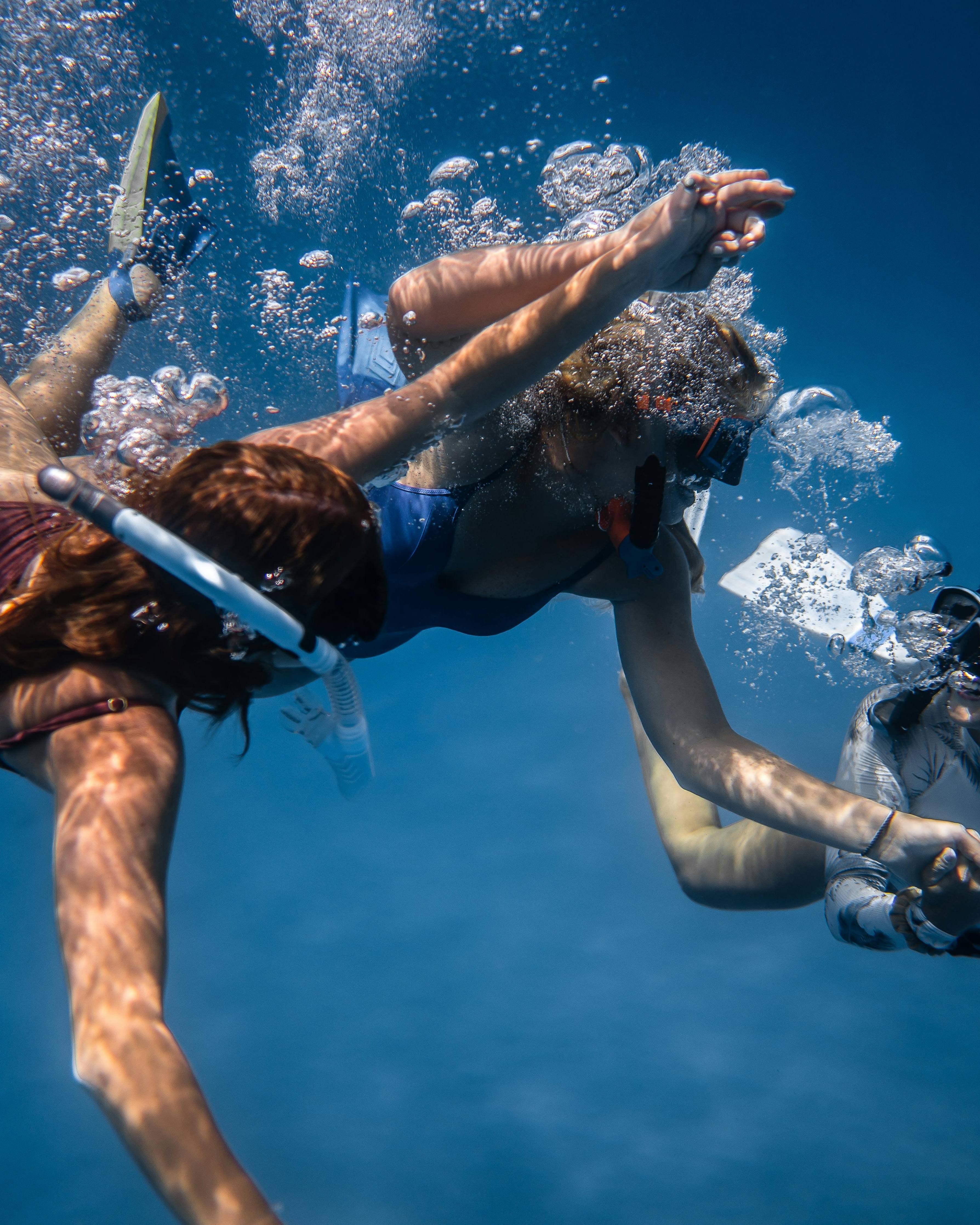 Three Snorkelers Swimming Underwater