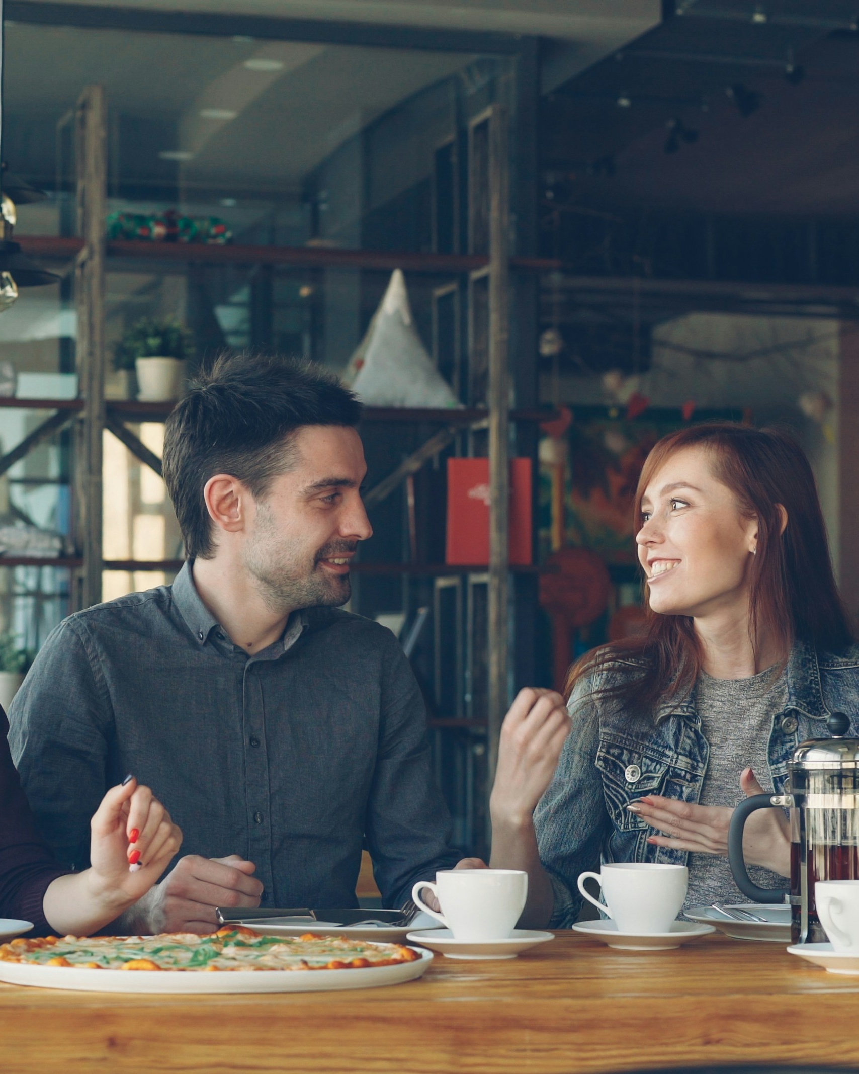 Friends Chatting Over Pizza at a Cafe