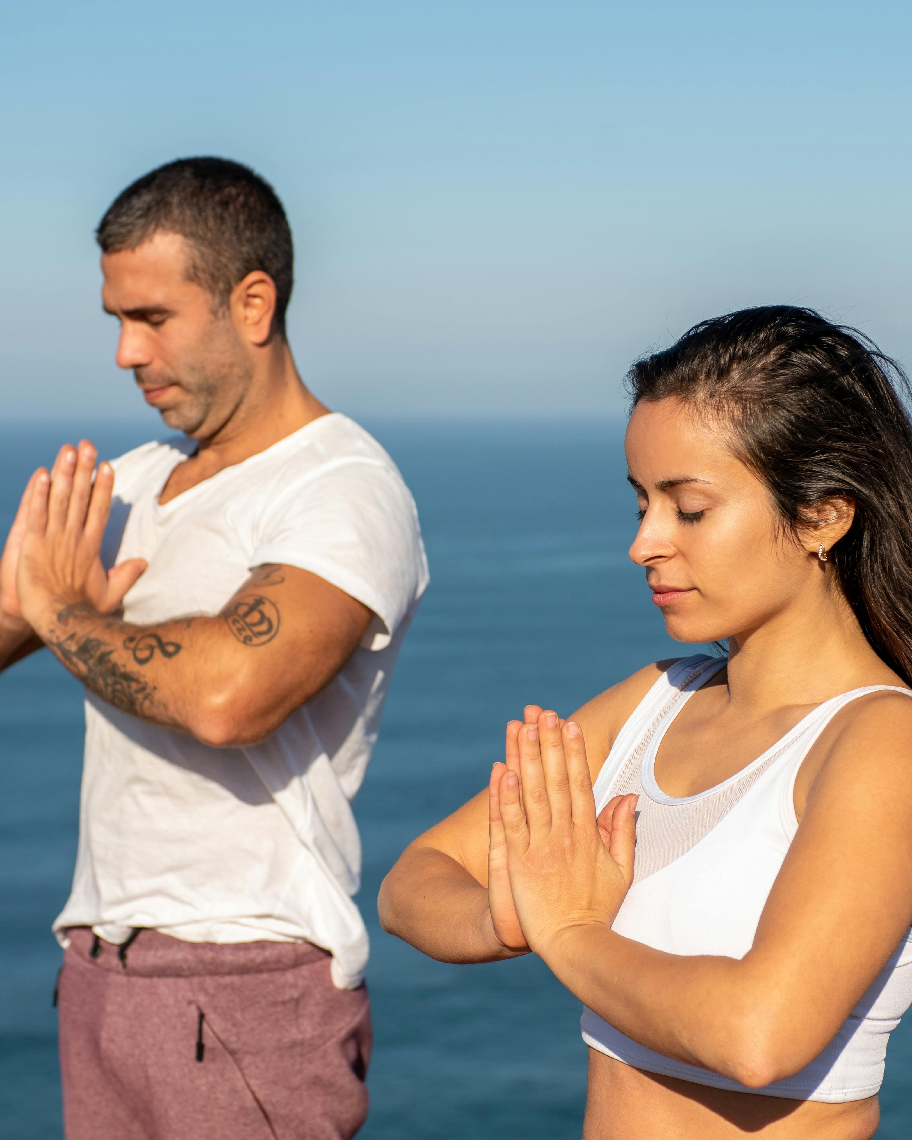 Couple Meditating By The Ocean