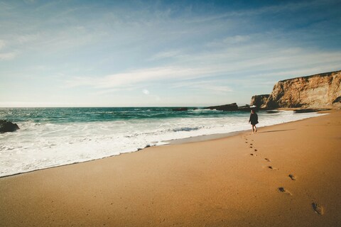 Lone Walker on Coastal Beach