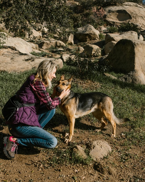 Woman Cuddles German Shepherd On Hike