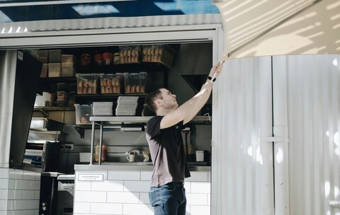 Man Adjusting Awning At Food Truck
