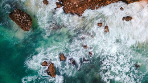 Aerial View of Coastal Waves Crashing on Rocks