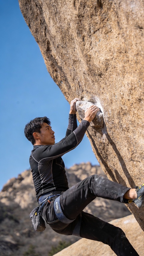 Man Rock Climbing On Natural Rock Face