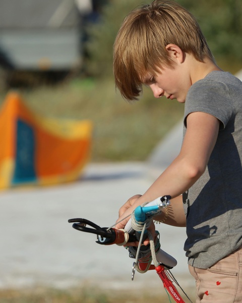 Boy Adjusting Kite Control Bar