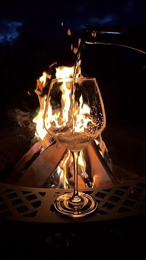 Pouring Wine by Night Campfire