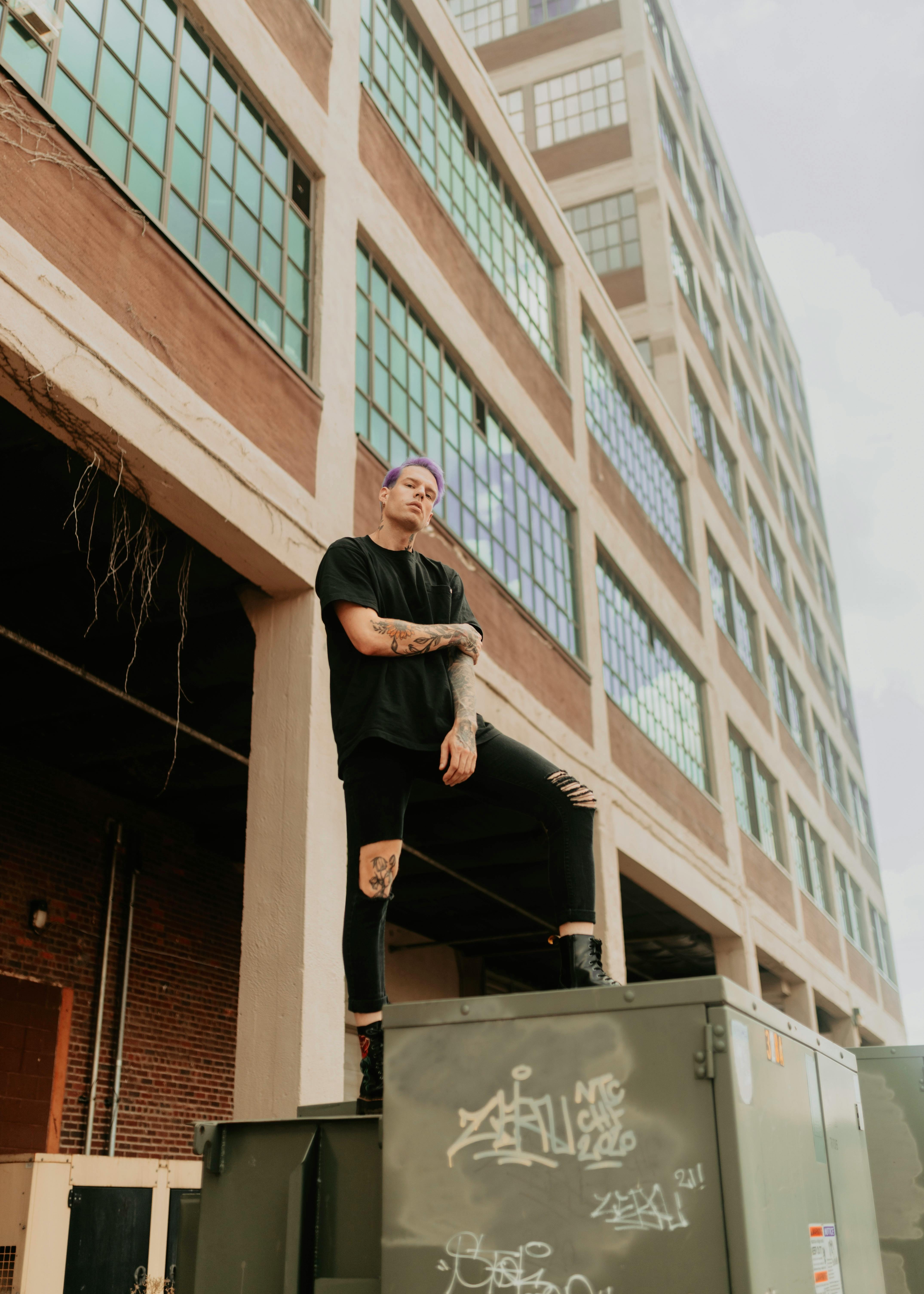 Purple-Haired Tattooed Man By Industrial Building