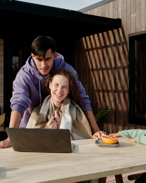Couple Viewing Laptop On Outdoor Patio