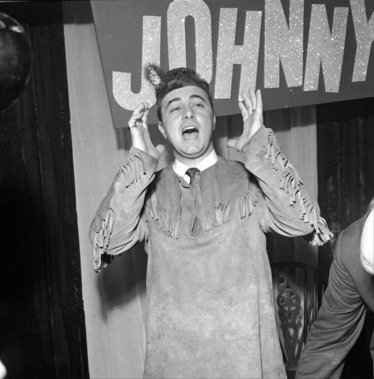 Costumed Man Cheering Under Johnny Sign