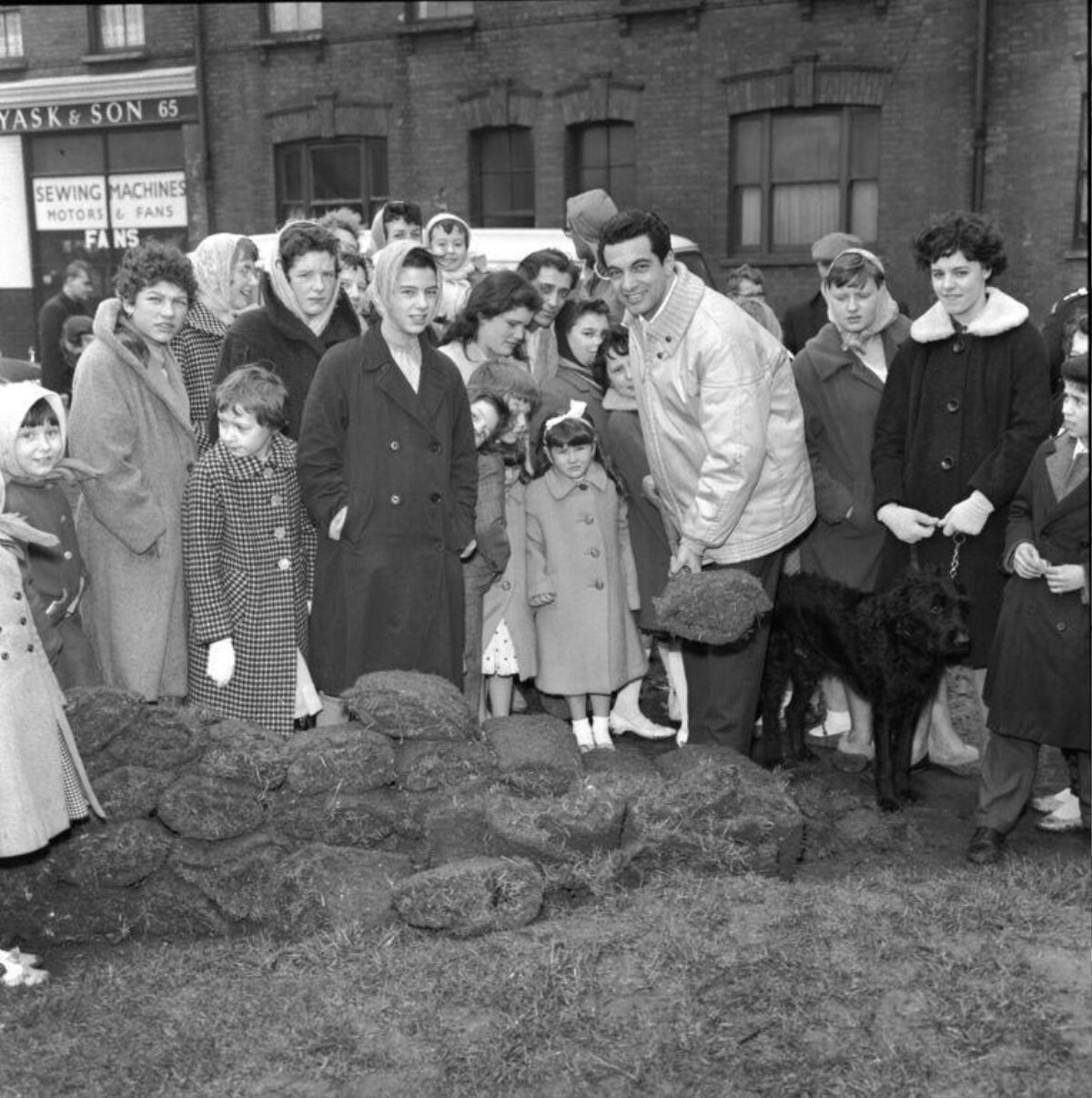 Crowd Gathered Around Stacked Peat Turf