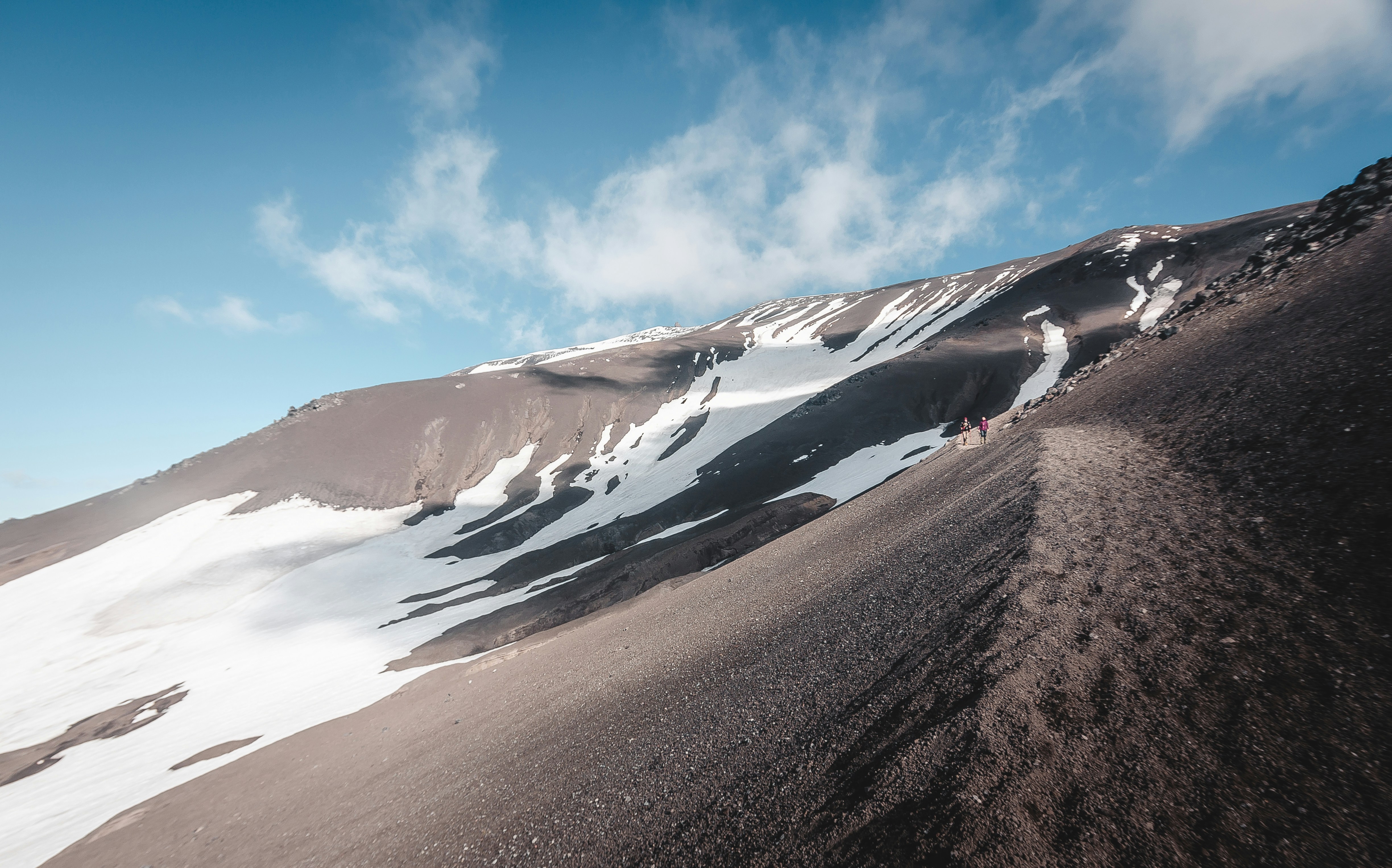 Hikers Trekking on Snowy Volcanic Slope