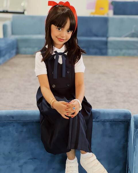 Young Girl in Kiki Cosplay on Blue Couch