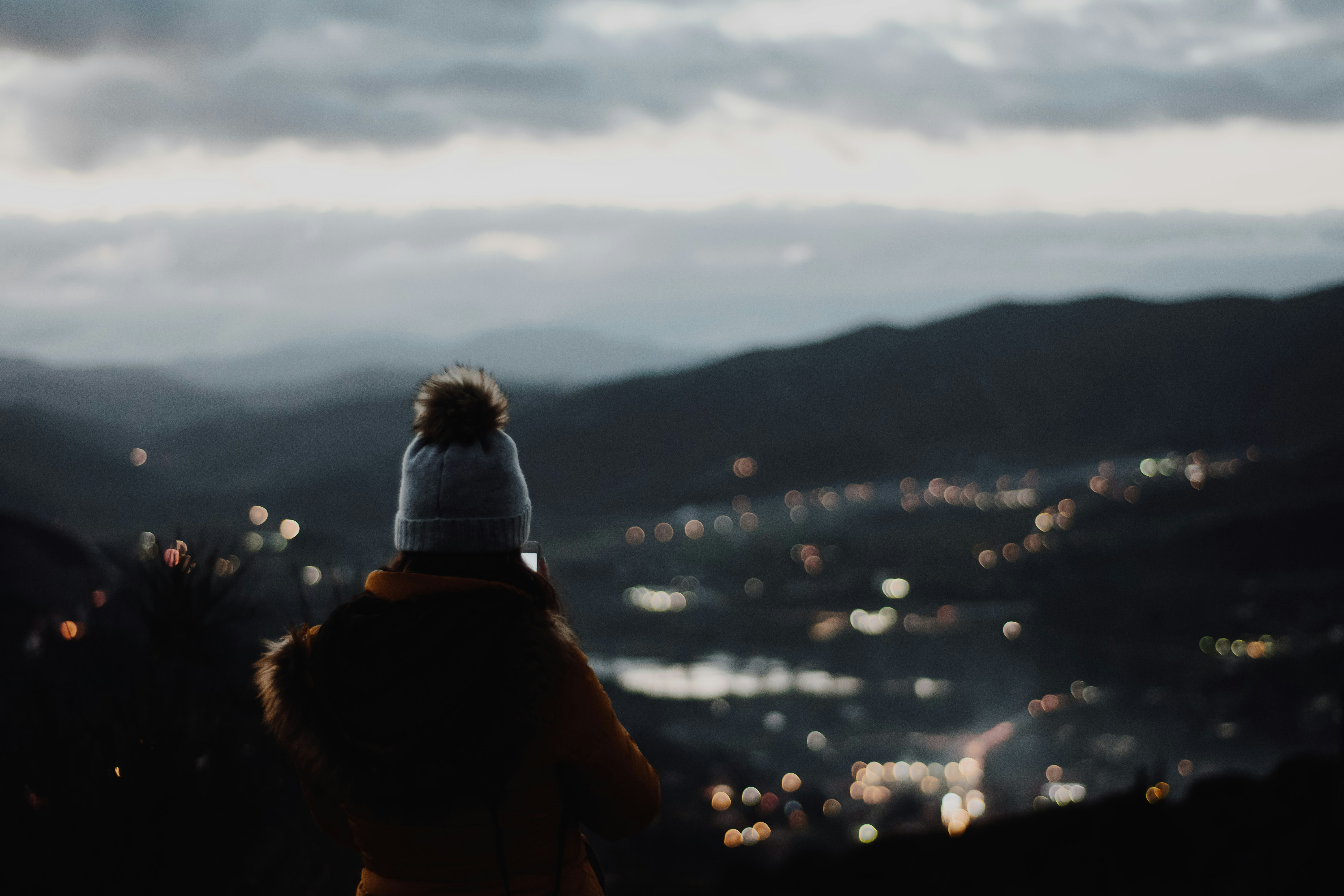 Hiker Overlooks Valley City Lights at Dusk
