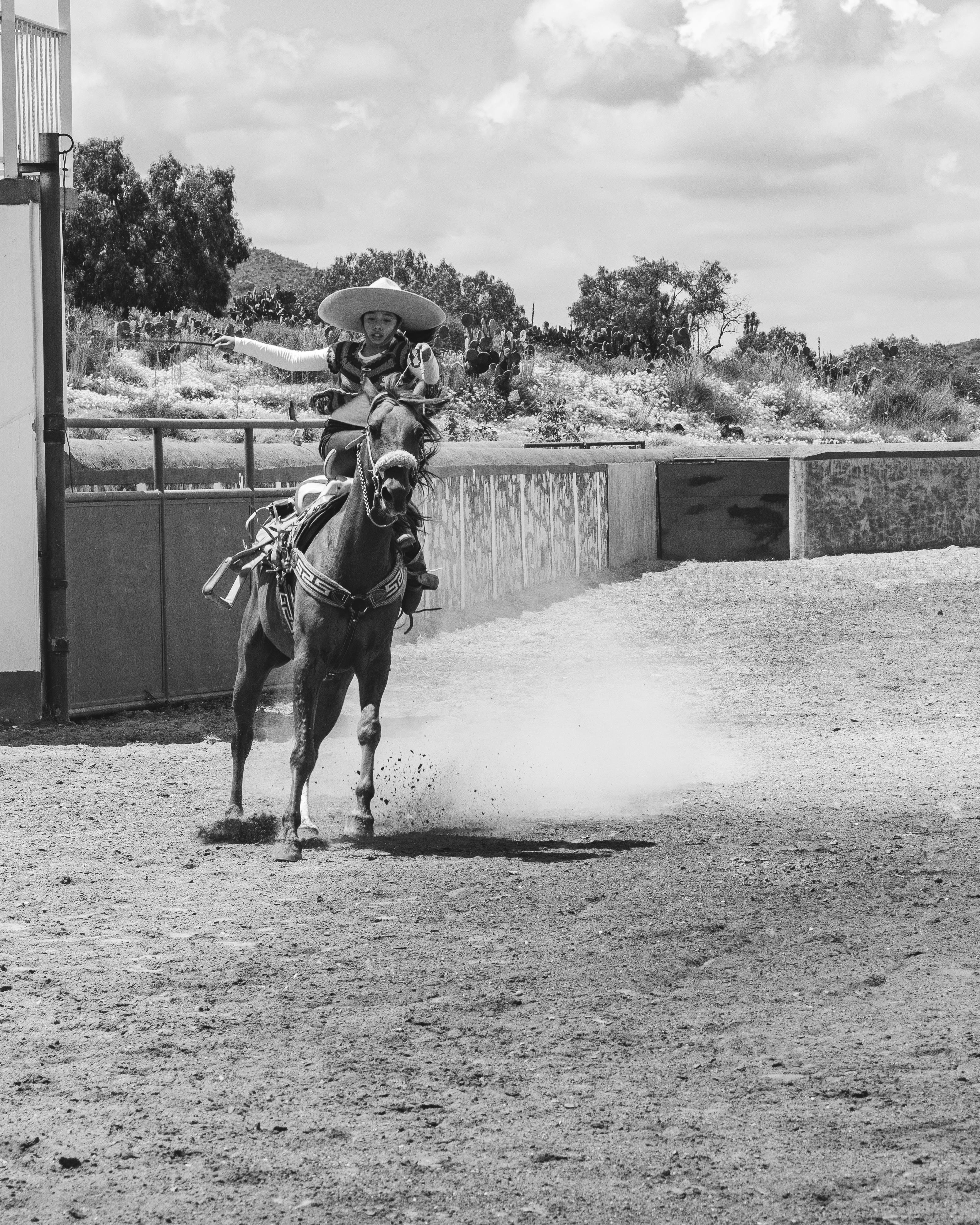 Charro Rider Galloping in Rodeo Arena