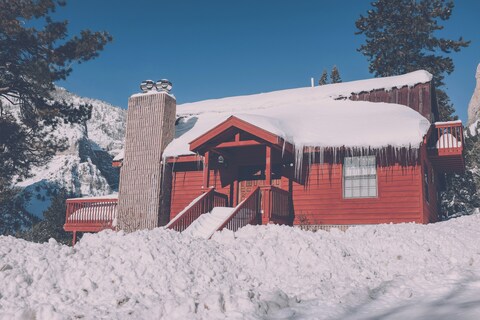 Red Wooden Cabin in Snowy Mountains