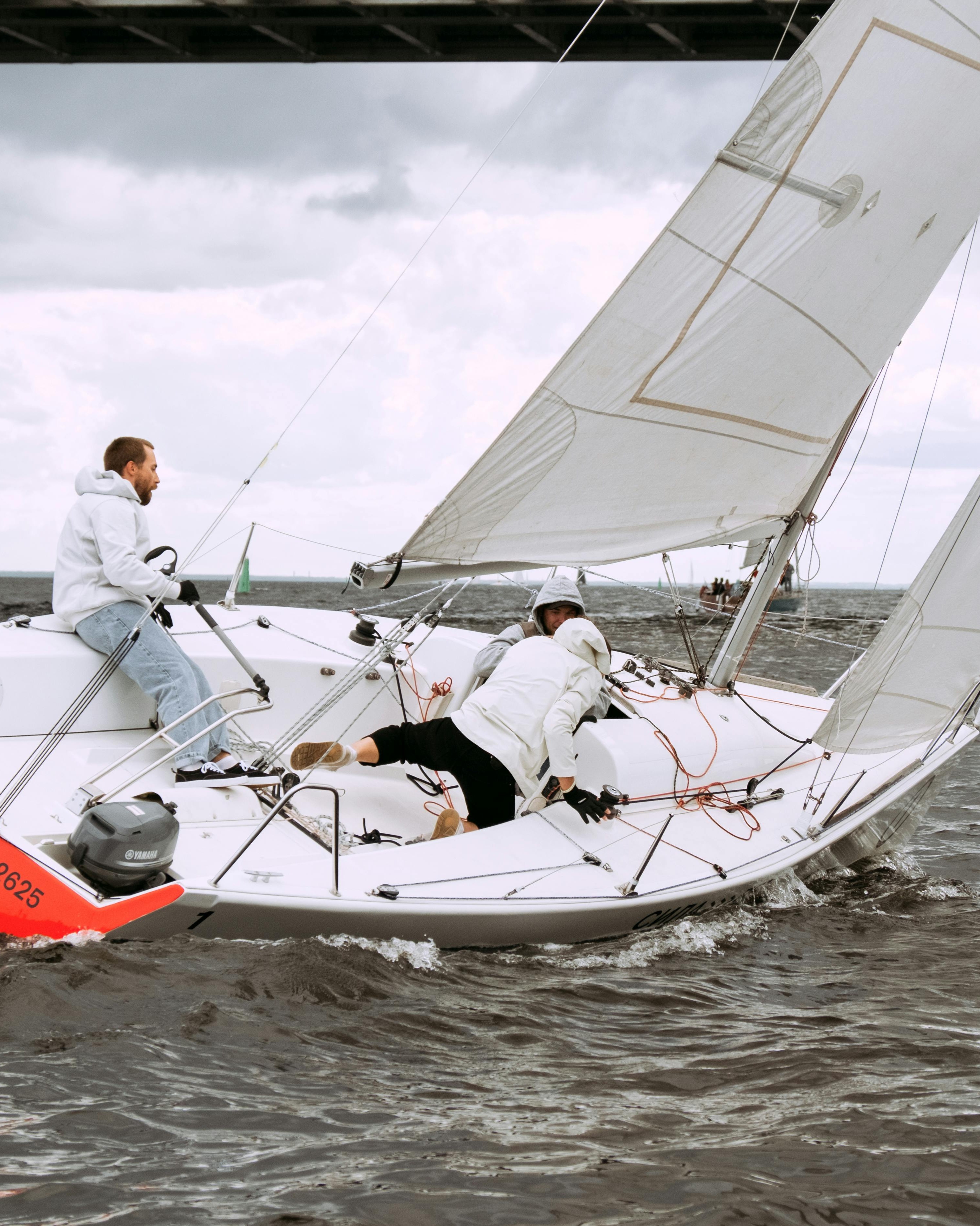 Three People Sailing on Open Water