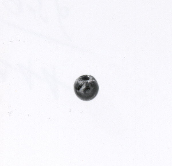 Single Small Black Bead on White Background — White Backgrounds