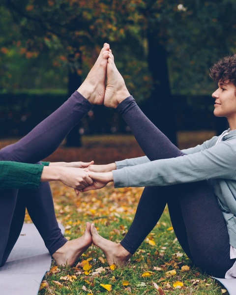 Two People Doing Partner Yoga Outdoors