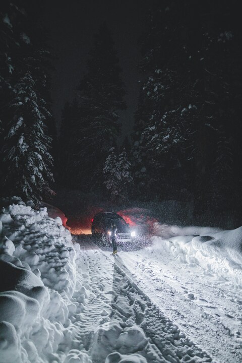 Snowy Night Forest Road with Car