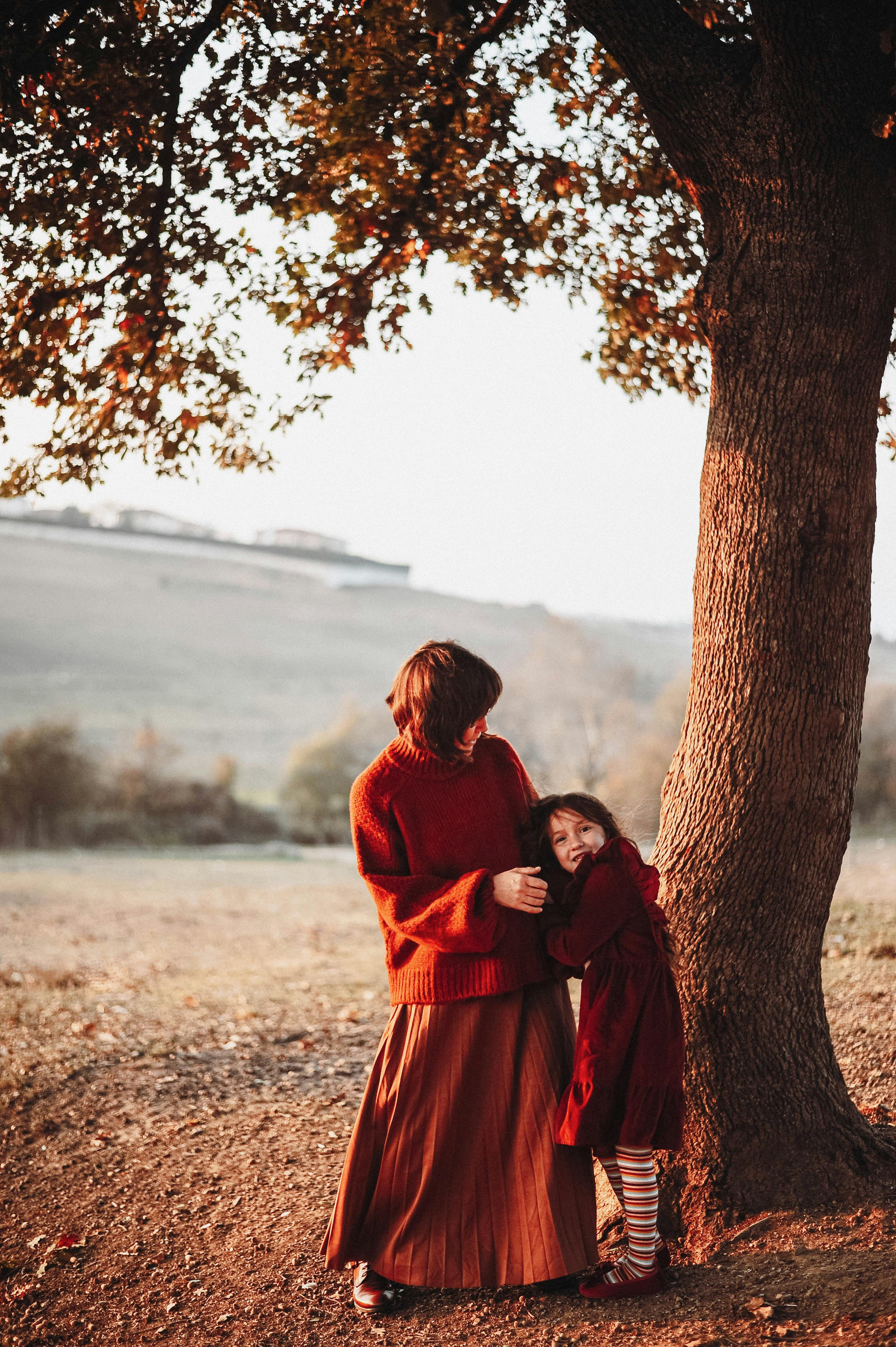 Mother and Daughter Under Autumn Tree