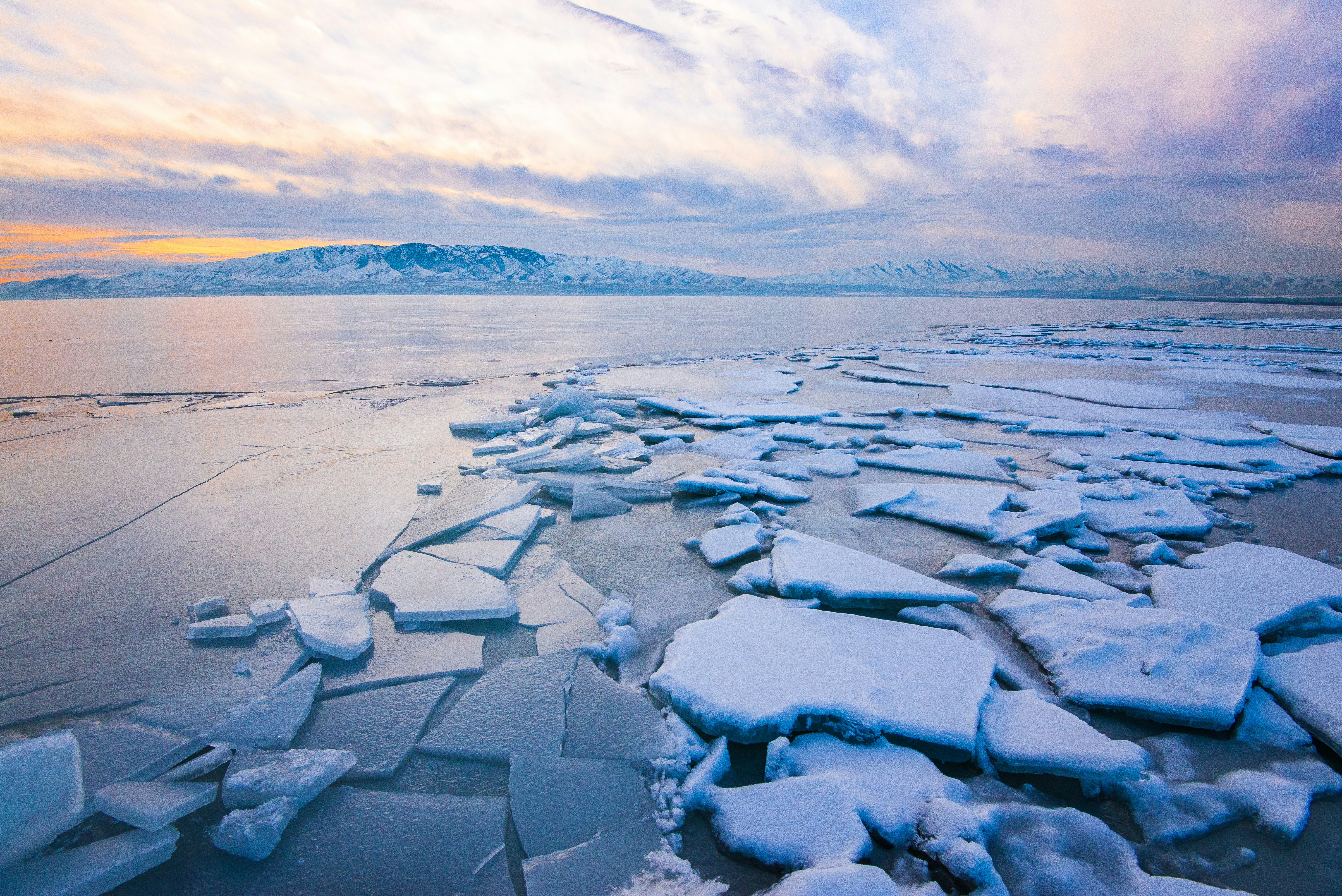 Frozen Lake With Distant Snowy Mountains