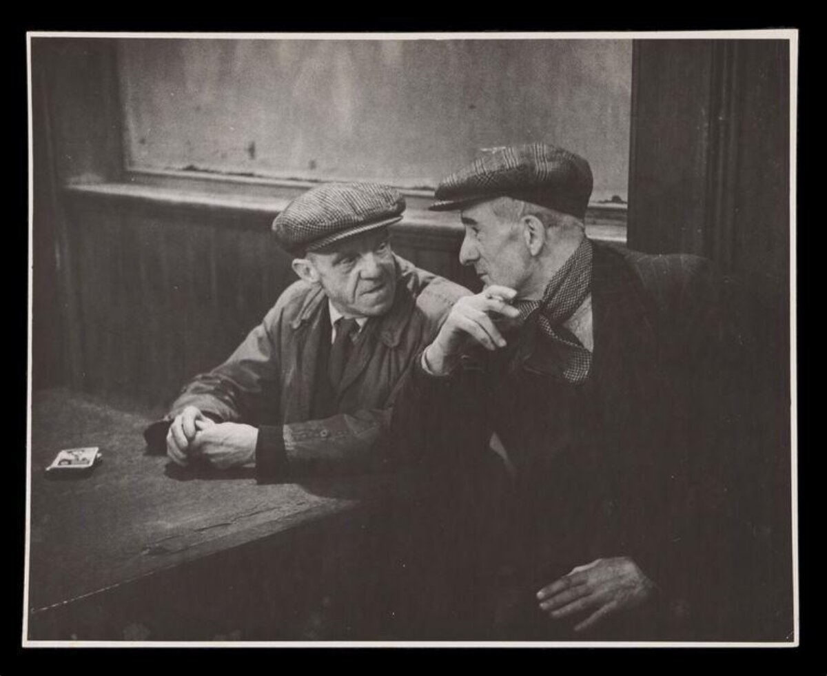 Two Working Men Chatting at Table
