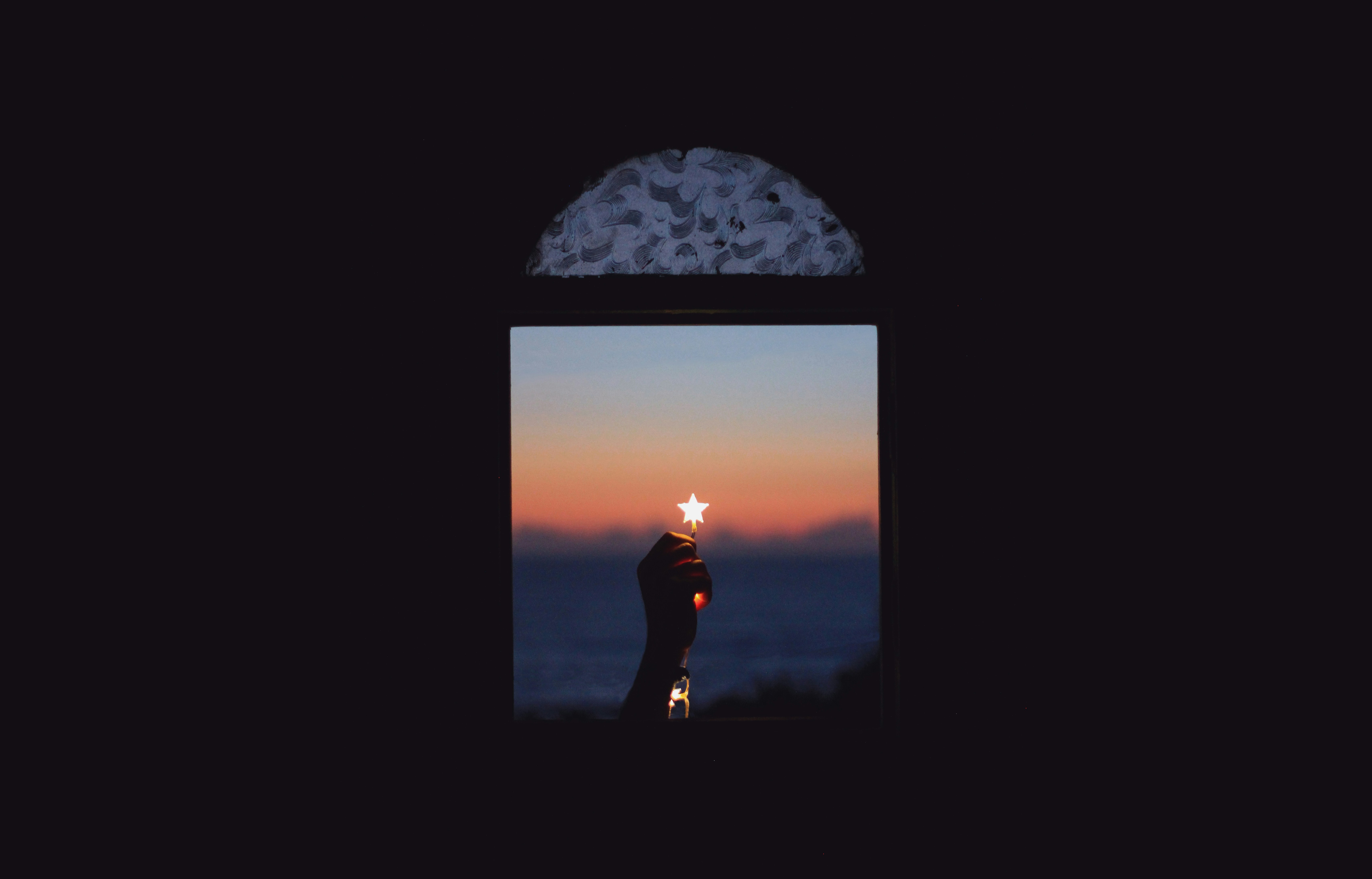 Hand Holding Star Light By Window At Dusk