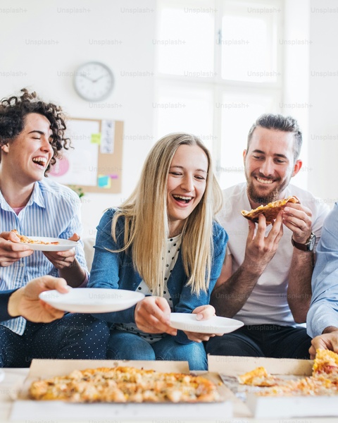 Friends Laughing While Eating Pizza