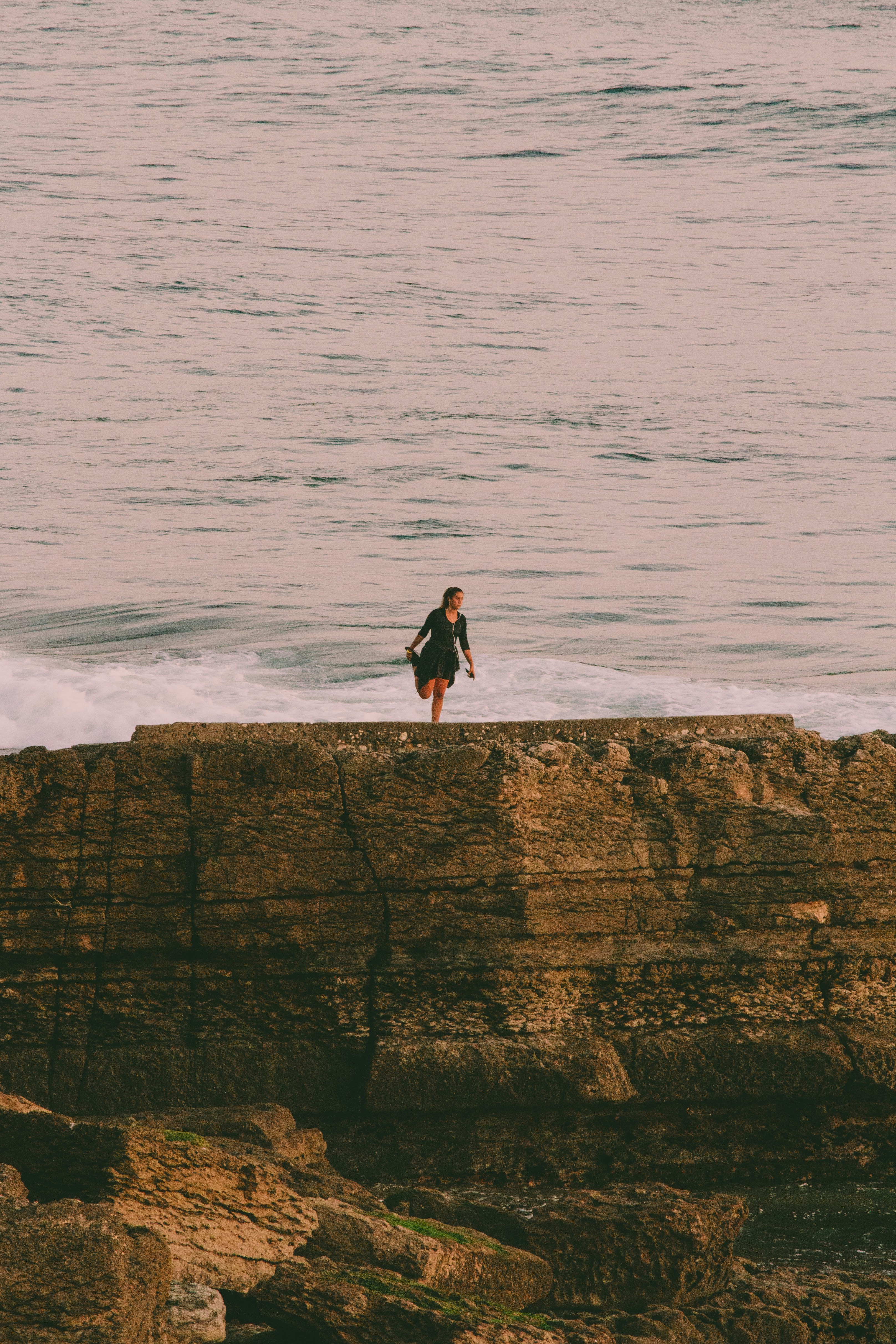 Woman Stretching on Coastal Breakwater