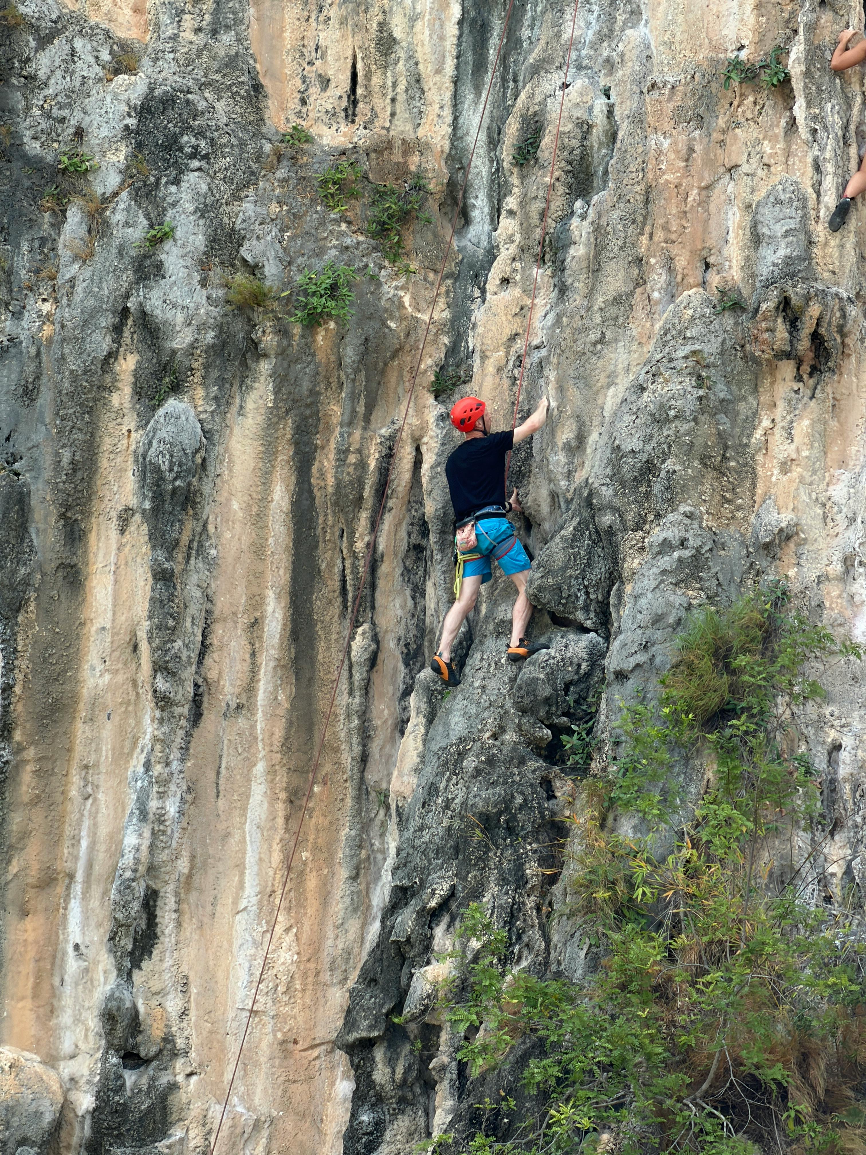 Rock Climber Ascending Natural Cliff