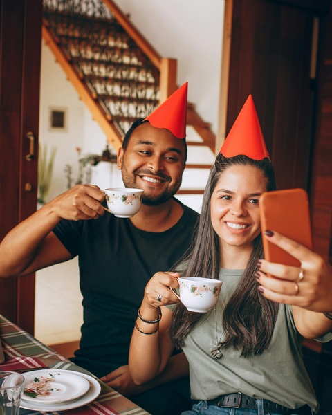 Couple in Red Party Hats Taking Selfie