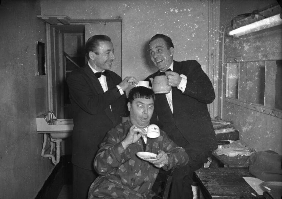 Three Men Joking Over Tea Backstage