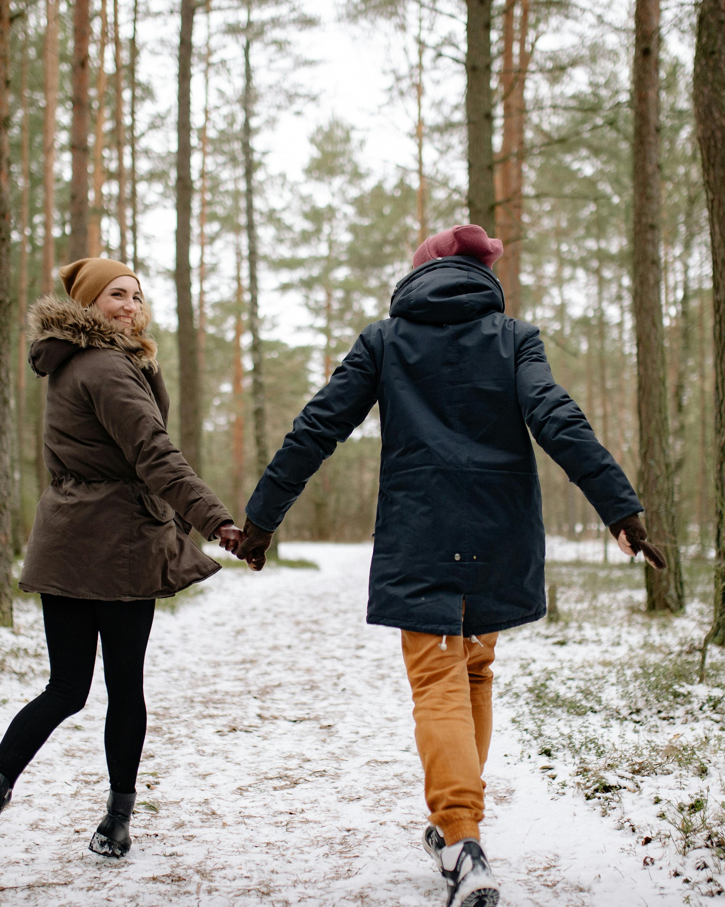 Couple Walking in Snowy Winter Forest