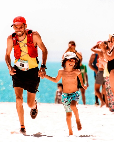 Man and Boy Running Hand in Hand on Beach