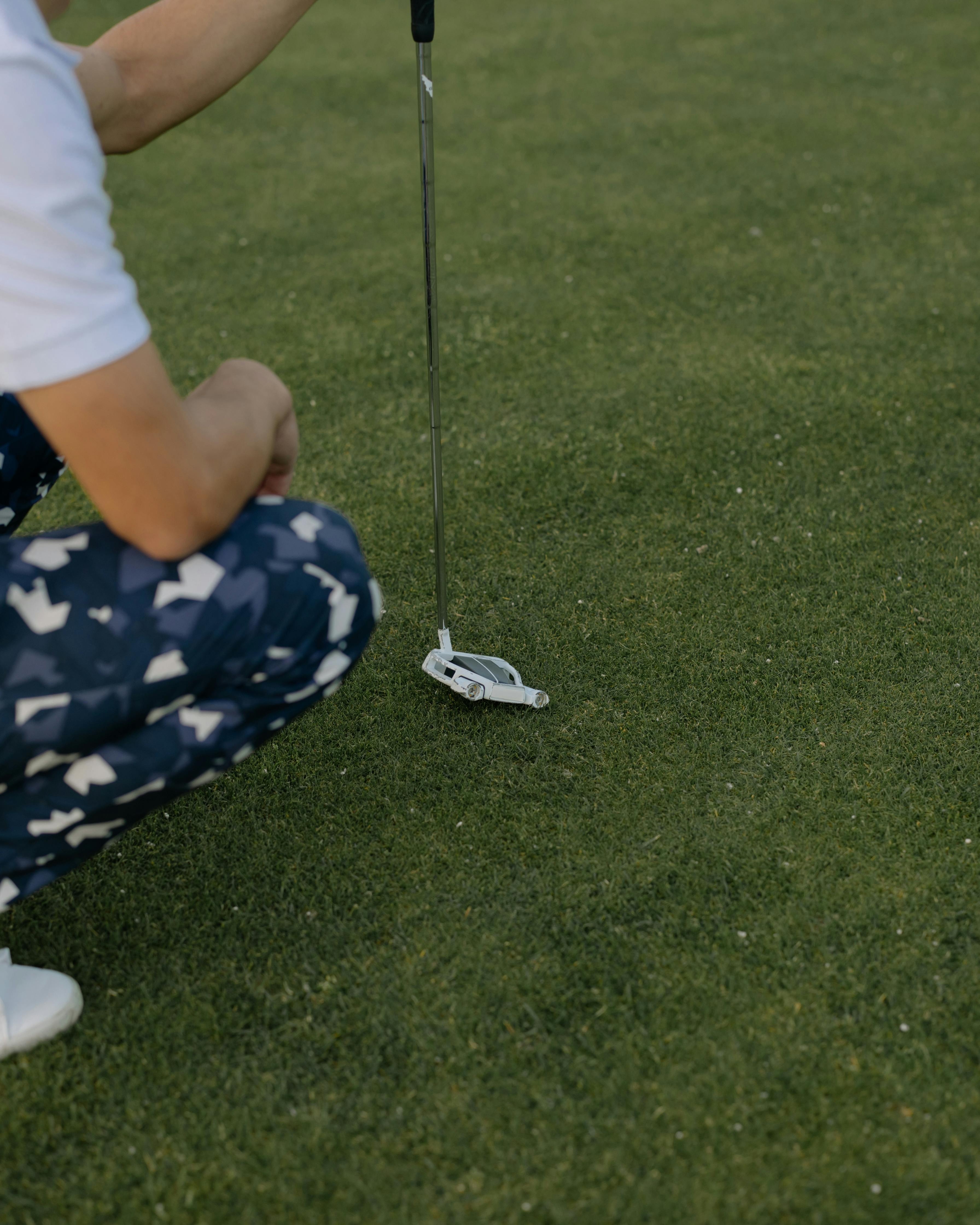 Golfer Crouching on Golf Green