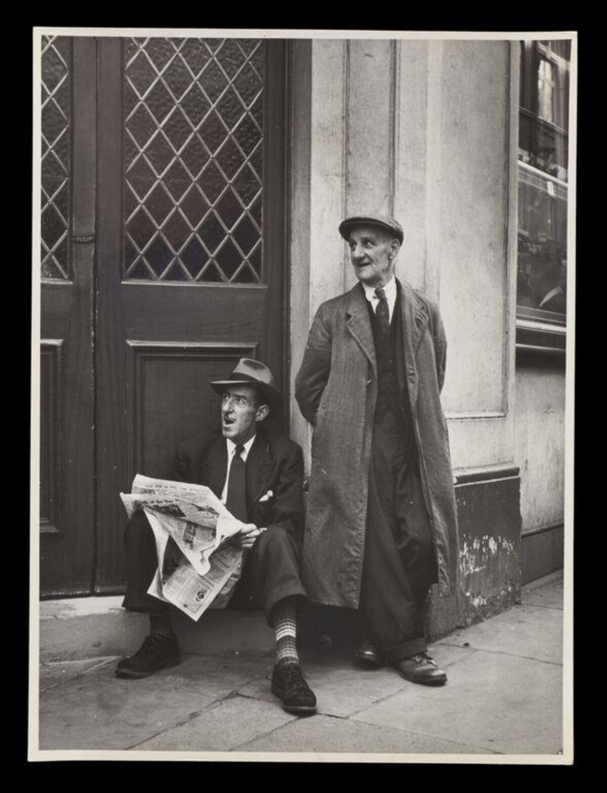 Two Men Resting on City Sidewalk