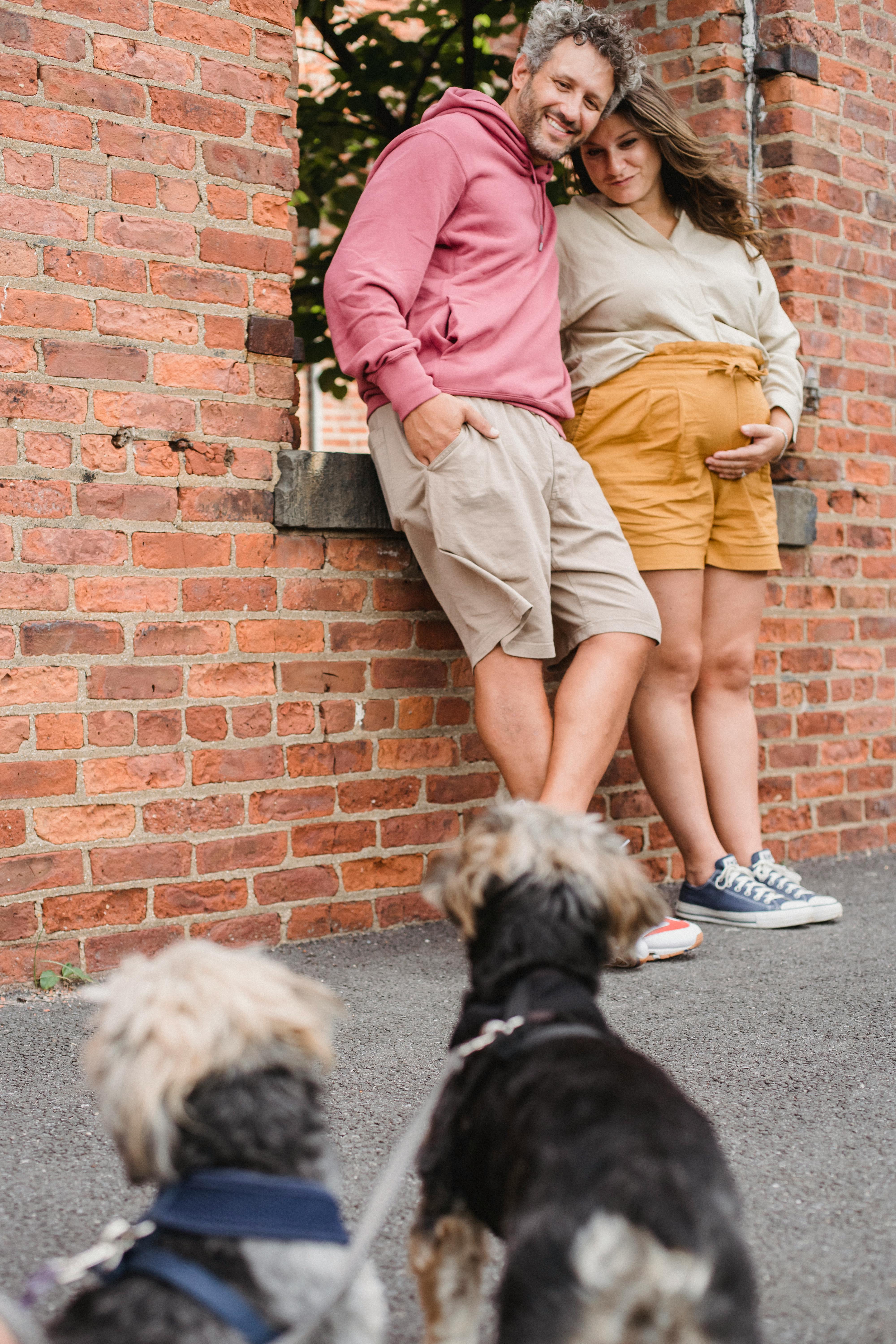 Expecting Couple With Two Dogs Outdoors
