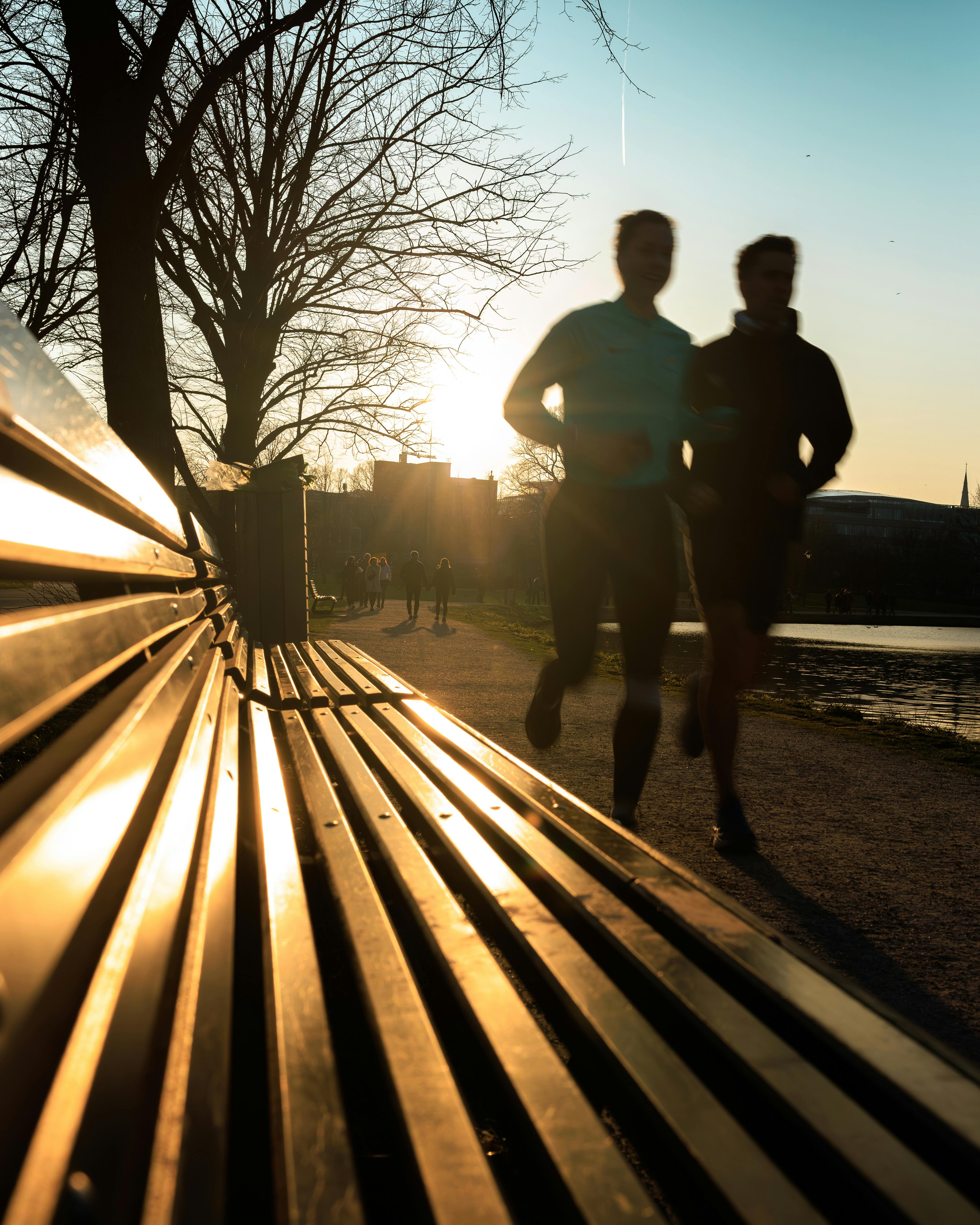 Two Runners Jogging in Park at Sunset