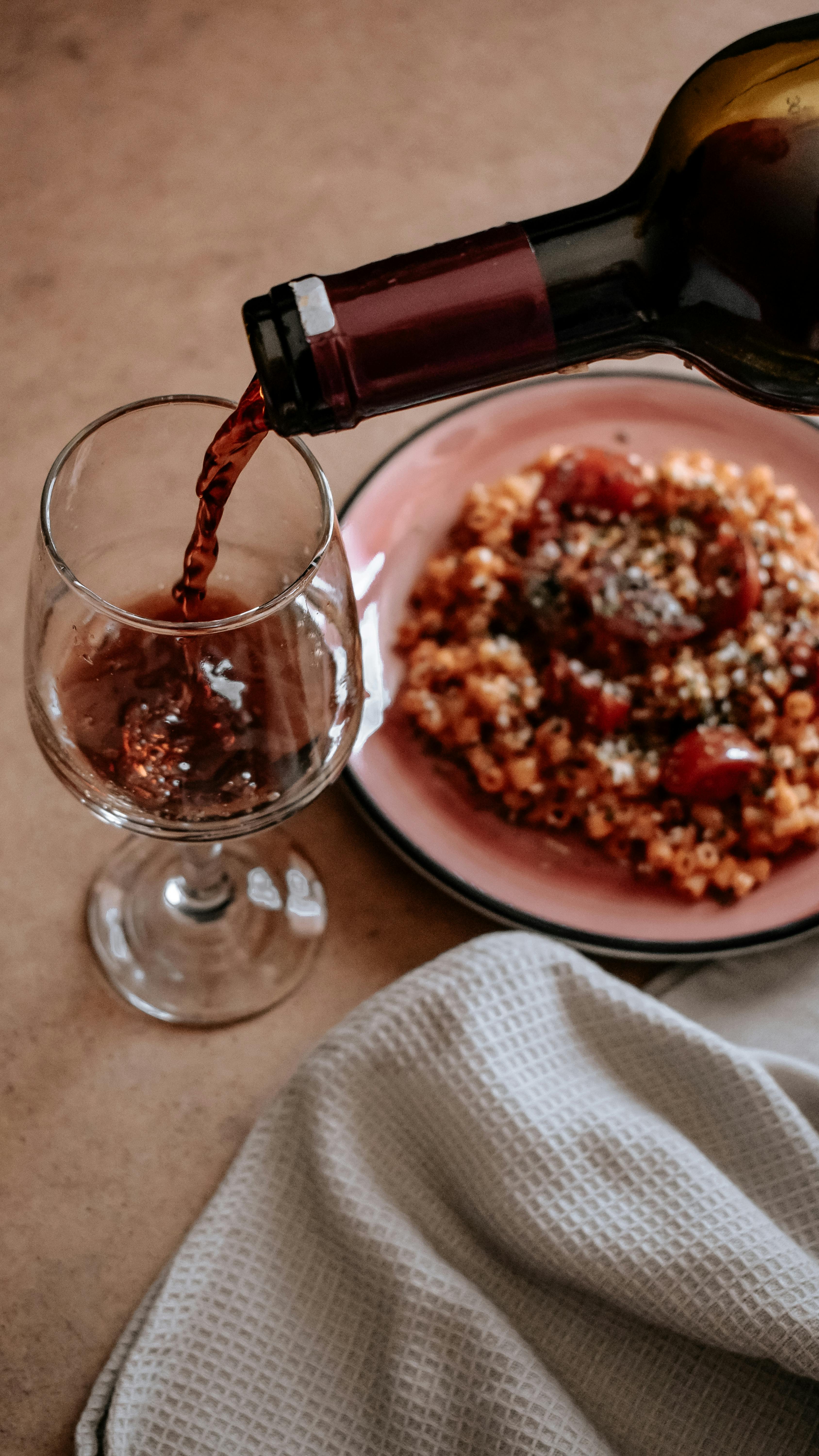 Pouring Red Wine with Pasta Dish