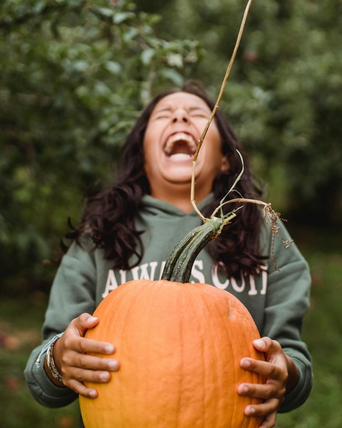 Laughing Woman Holding Large Pumpkin
