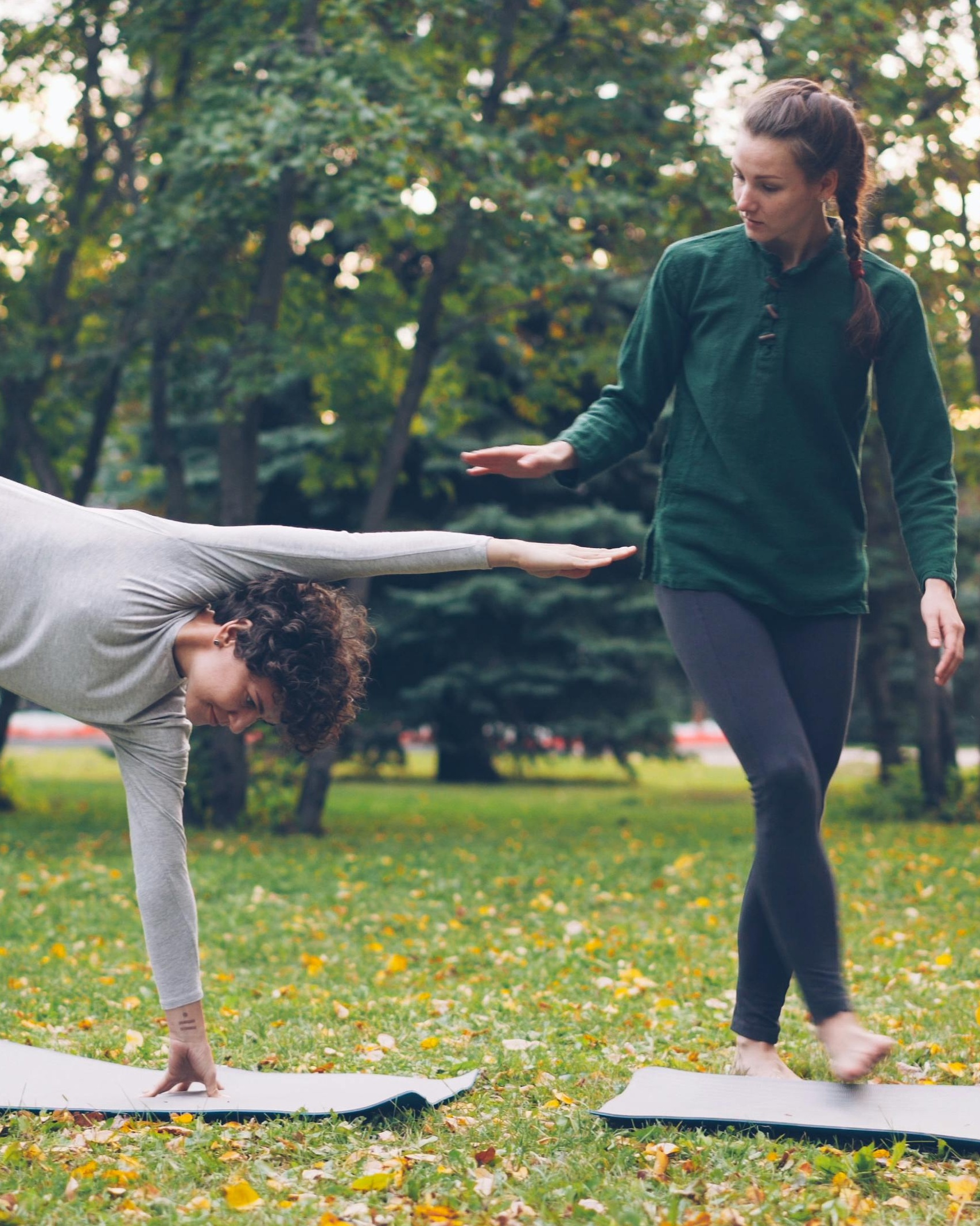 Two Women Practicing Yoga in Park