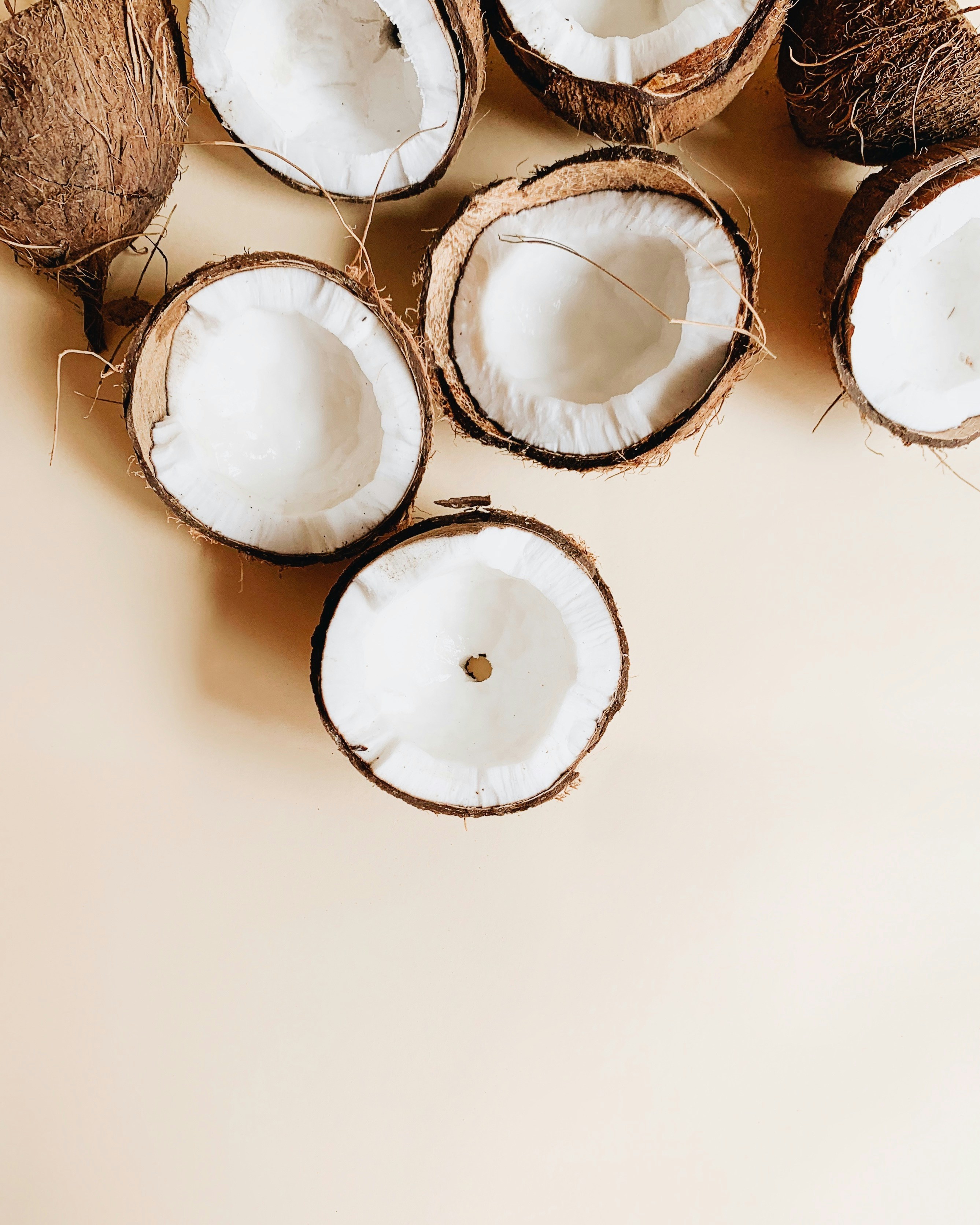 Halved Coconuts on Beige Background