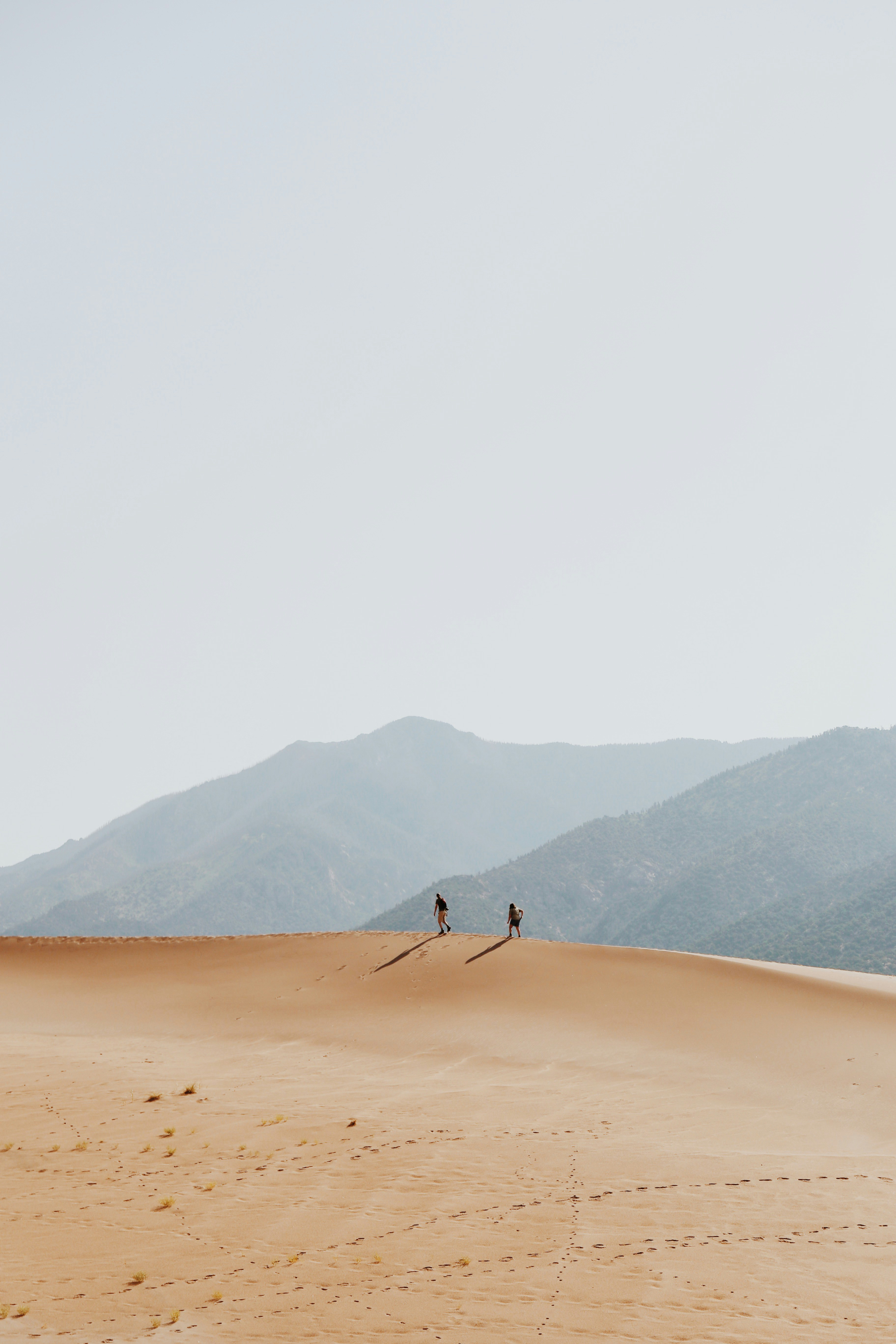 Two Hikers on Desert Sand Dunes