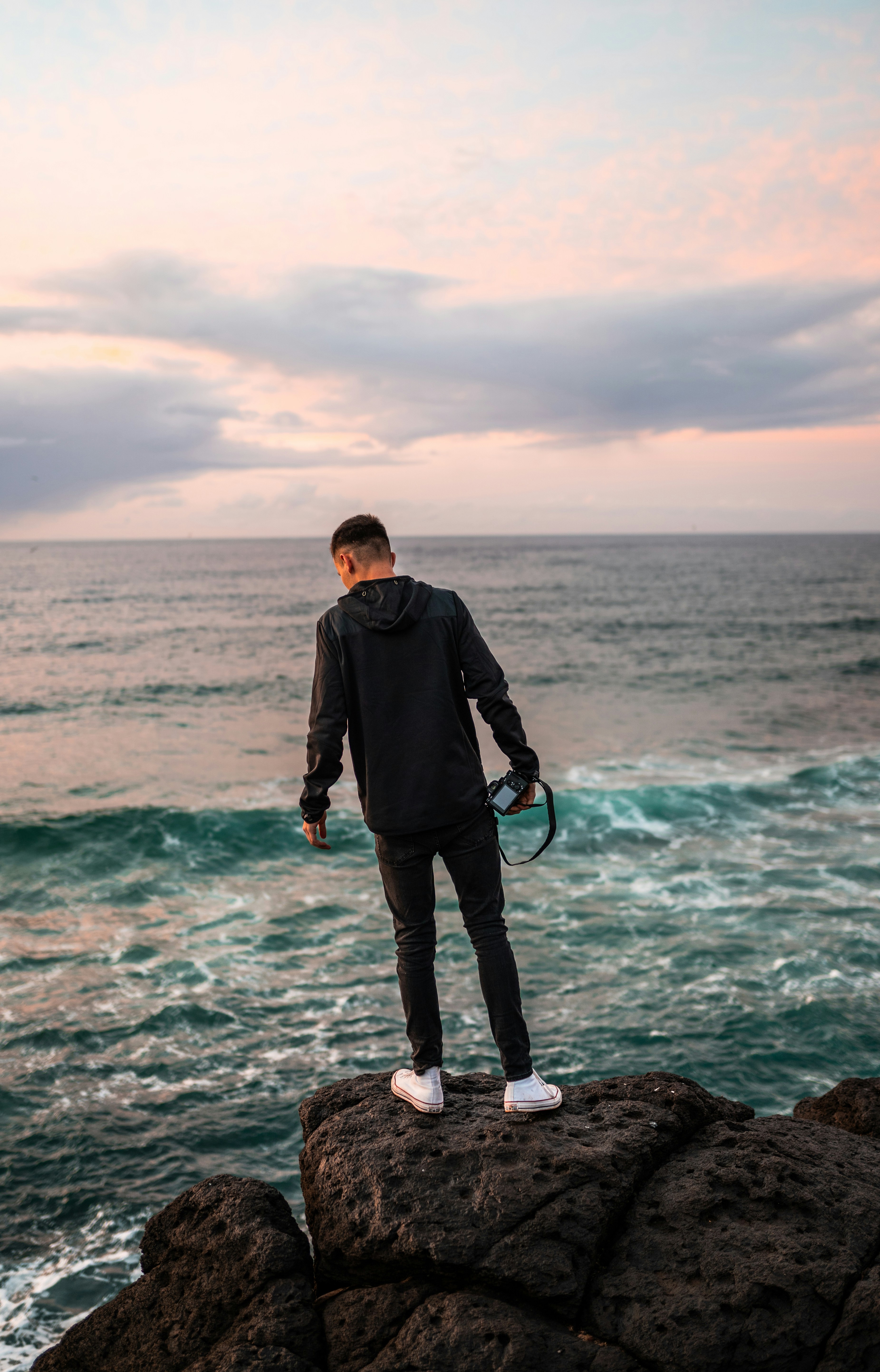 Photographer Overlooking Sea on Cliff