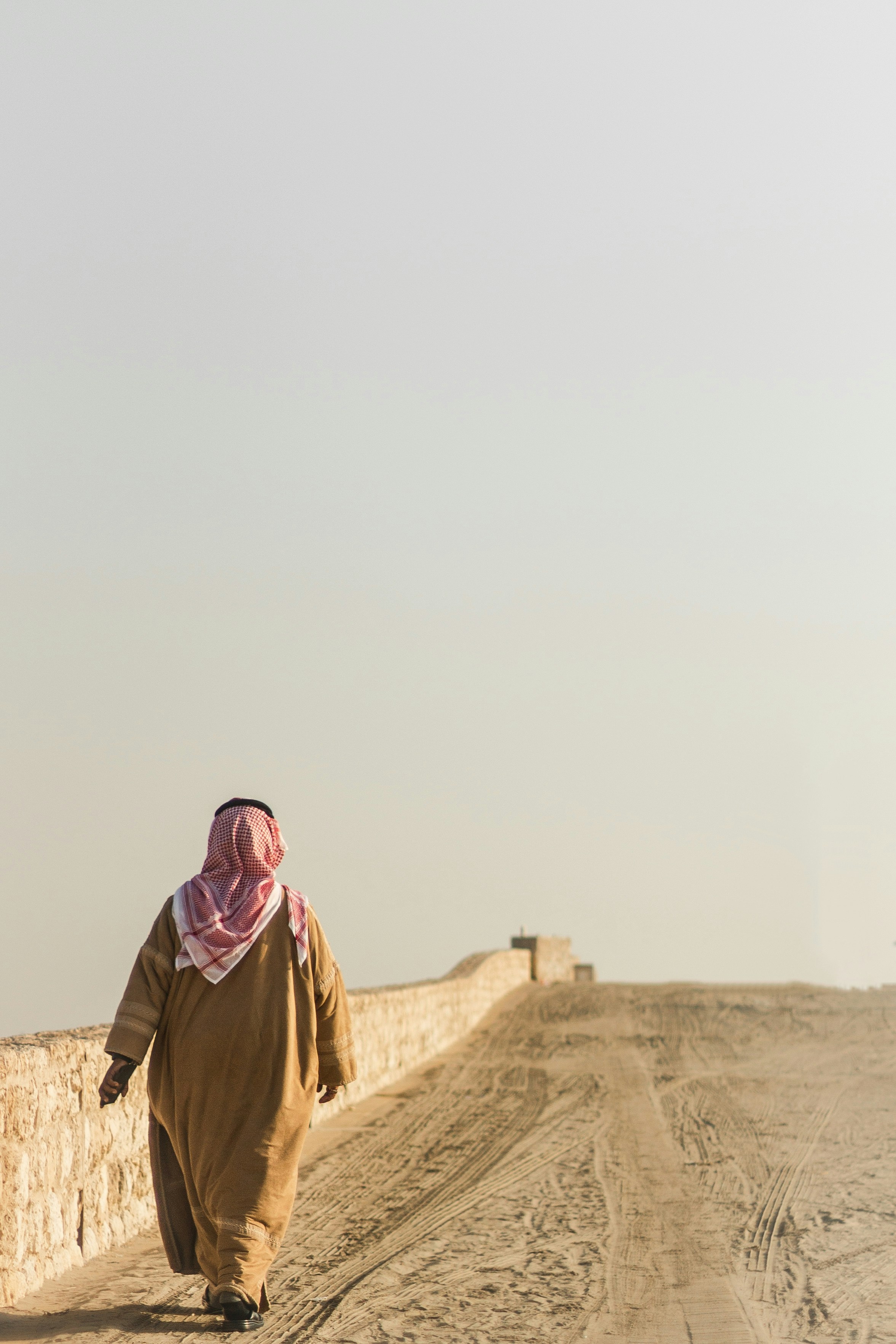 Man in Traditional Attire Walking Desert Path