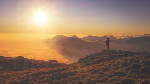 Hiker on Mountain Peak at Sunrise